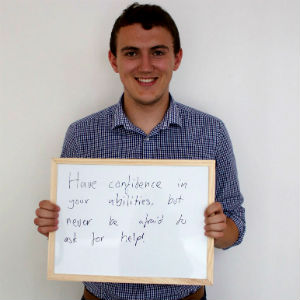 Osian holds a sign saying: have confidence in your abilities but never be afraid to ask for help