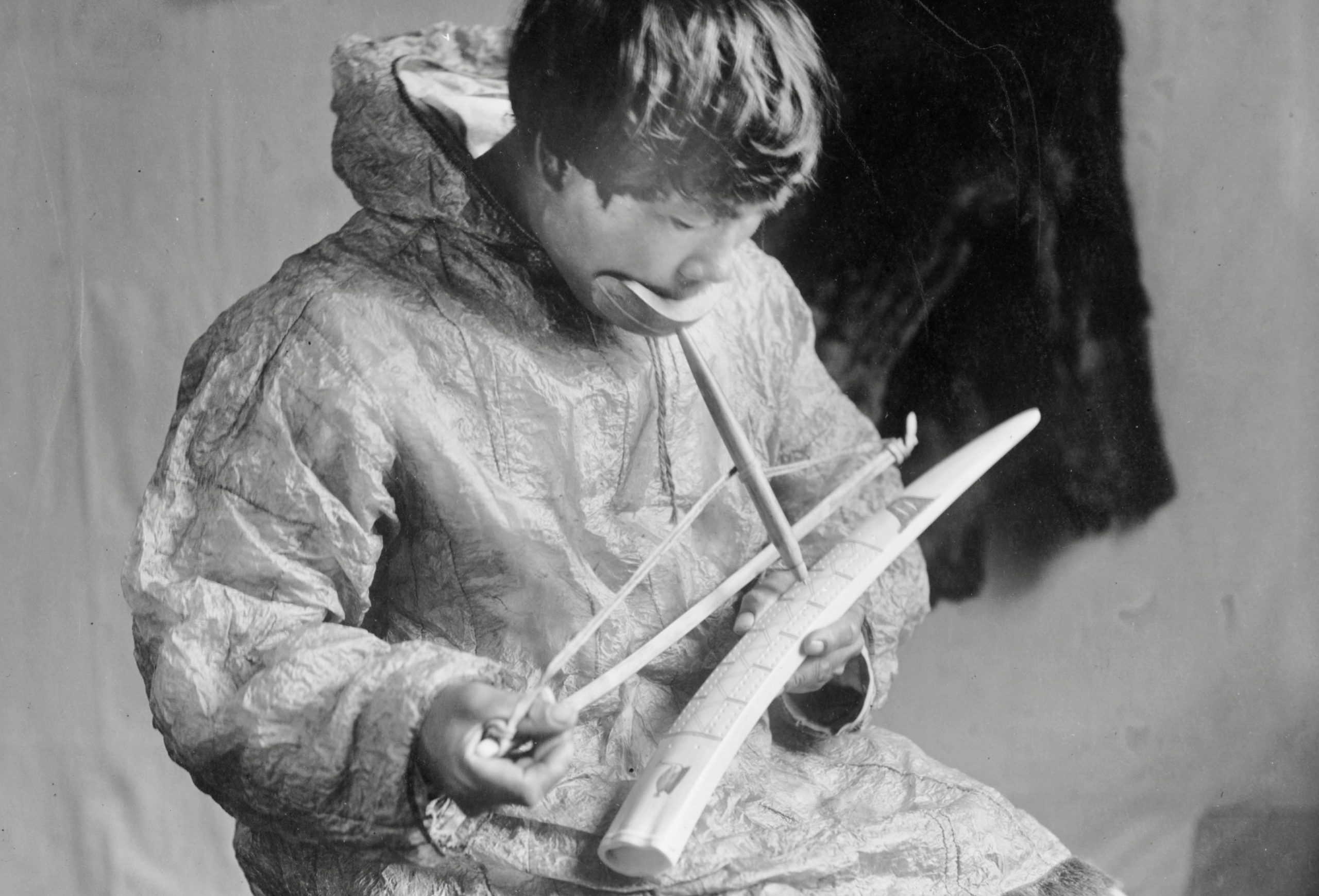 Inupiaq ivory carver with a bow drill, working on a cribbage board, circa 1912 in Nome. (Library of Congress)