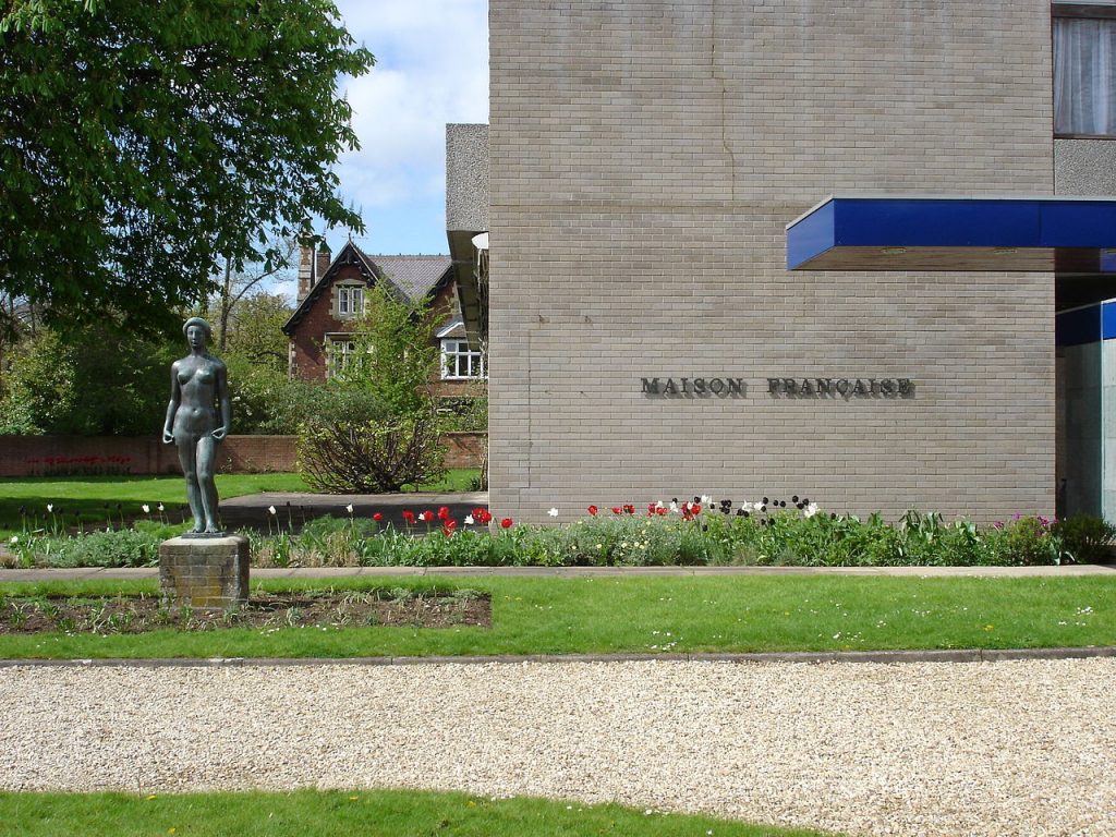 Photograph of the Maison Française d'Oxford building and its garden, with a statue in the foreground.