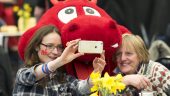 Two ladies taking a photograph with Dylan the Dragon (Photo by Matthew Horwood)