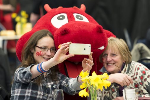 Two ladies taking a photograph with Dylan the Dragon (Photo by Matthew Horwood)