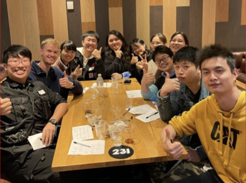 Group of society members sat around a table.