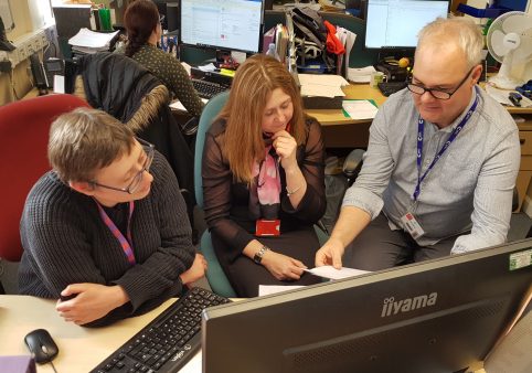 Ronnie and Sarah working around a computer on Do Different Day with Mark Goddard.