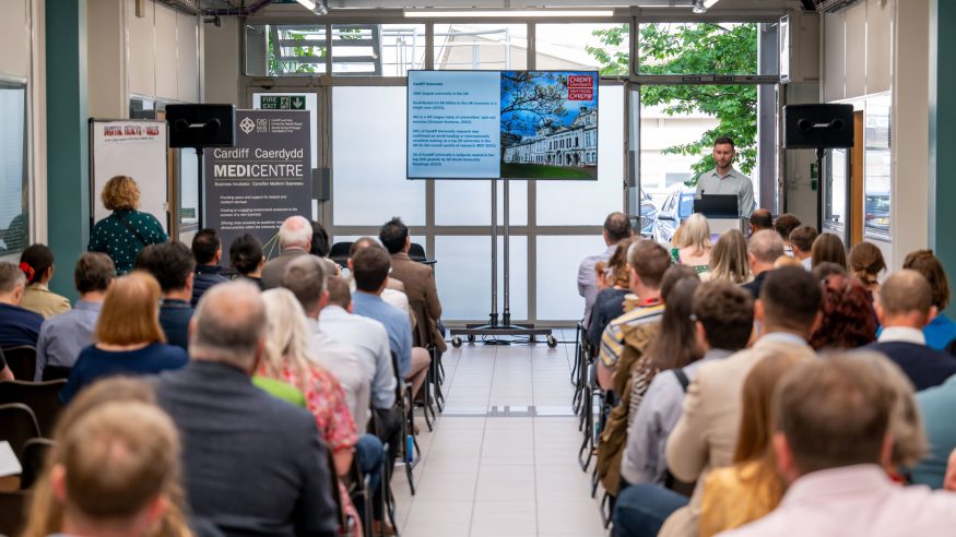 A man speaks to a large audience at the CUIN event