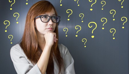 Woman thoughtfully trying to decide something surrounded by question marks