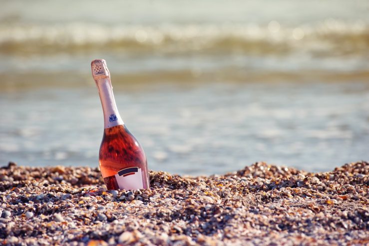bottle of rose cava in a bucket on the beach