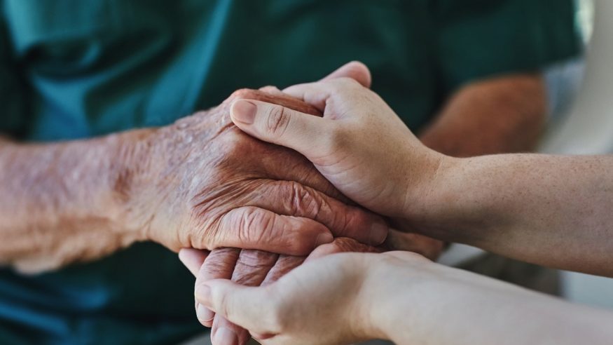 Younger hands kindly holding older hands