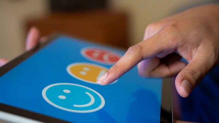 Person picking a happy face on a computer screen