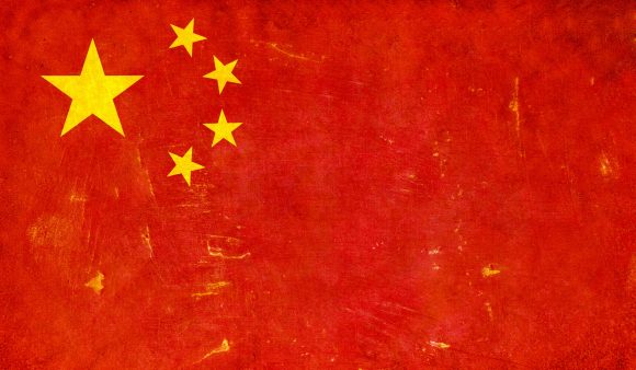 Grunge Chinese flag on rough edged wall background