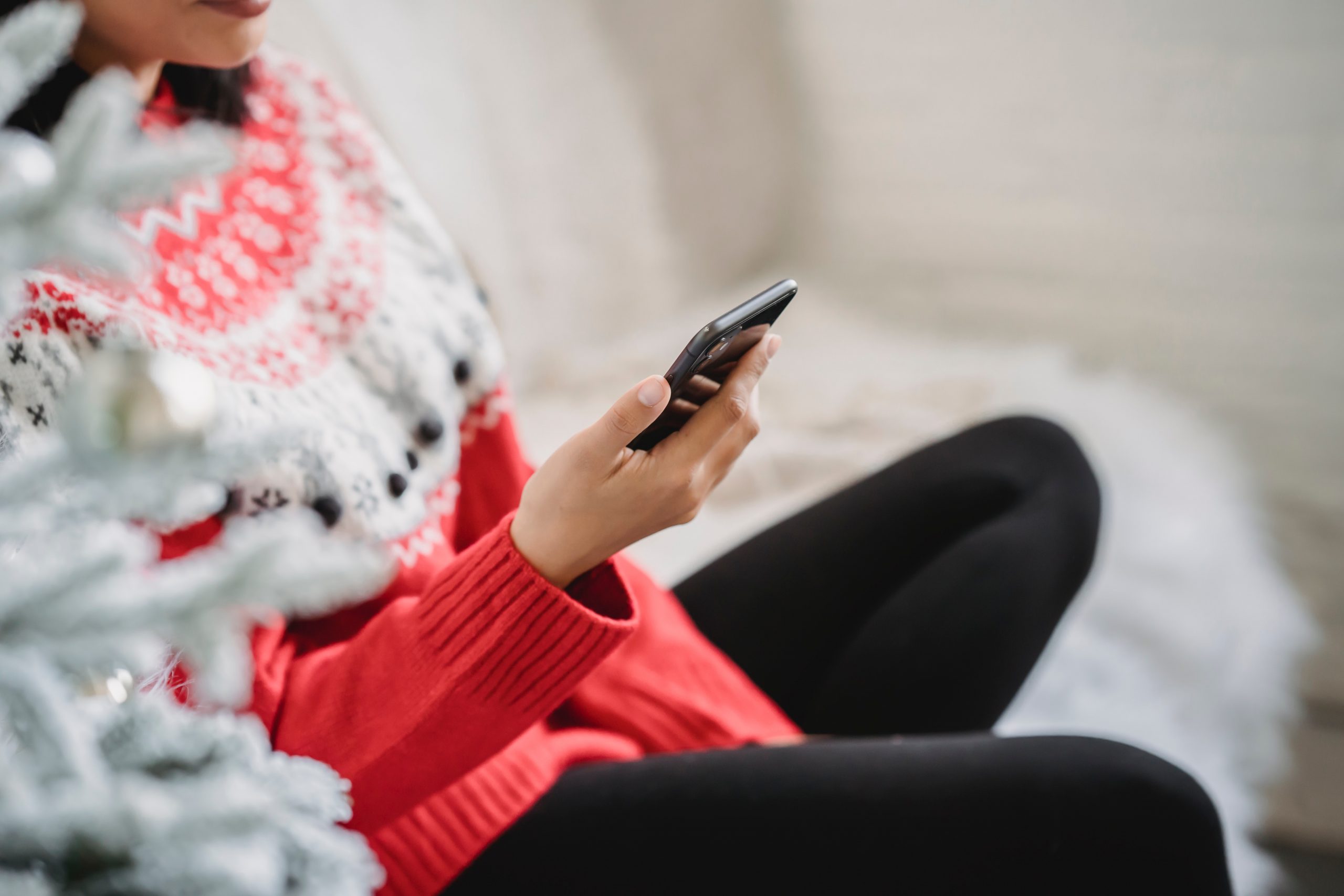 person in a Christmas jumper on phone