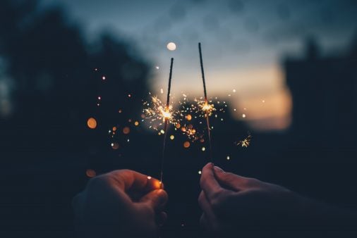 two people hold sparklers